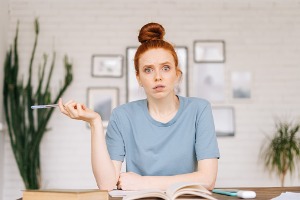 Surprised redhead sitting at table 